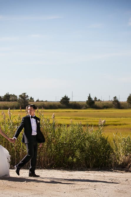 Bride and groom walk down a path on Bonnet island