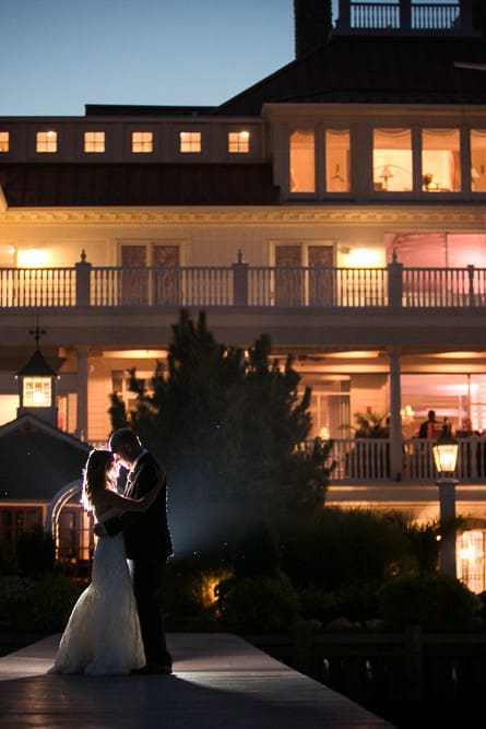 night photograph of bride and groom in front of Mallard Island Yacht Club