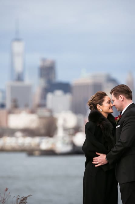 bride and groom posing in front of Manhattan skyline
