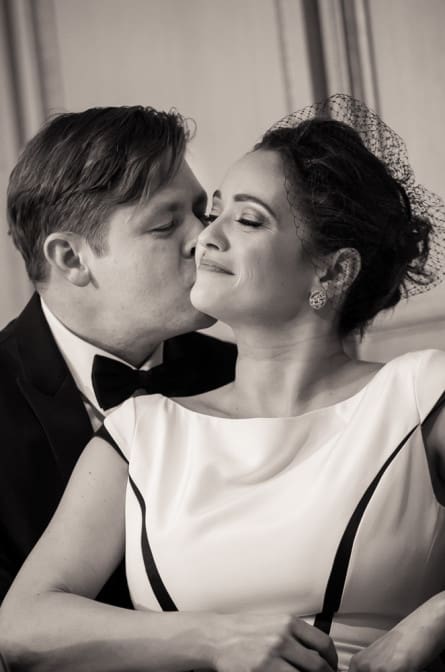black and white photo of groom kissing the bride's cheek