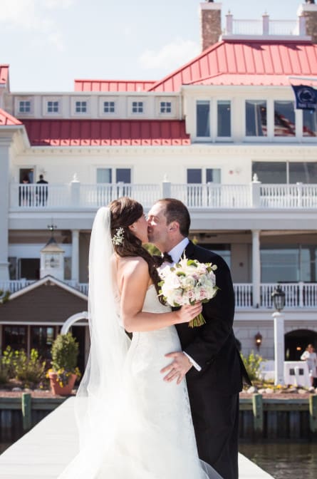 Jackie and Matt kissing in front of the venue at Mallard Island Yacht Club