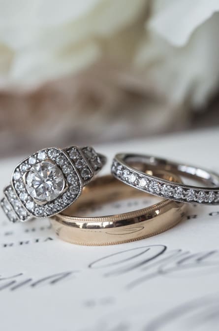 Christina and Ryan's wedding rings photographed with their invitation at NYLO
