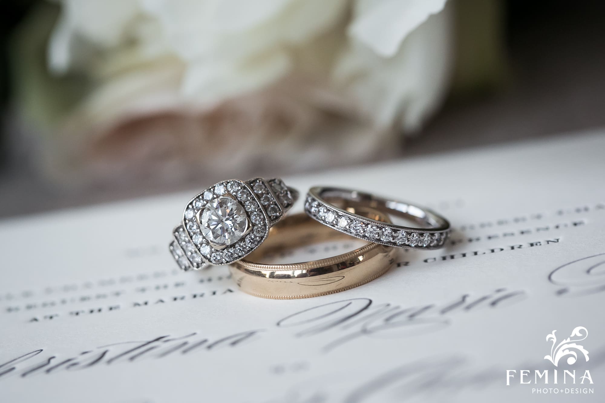 Christina and Ryan's wedding rings photographed with their invitation at NYLO