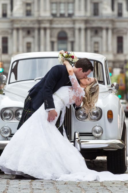Lyall dips his bride Rebecca in front of City Hall on Broad St in Philadelphia