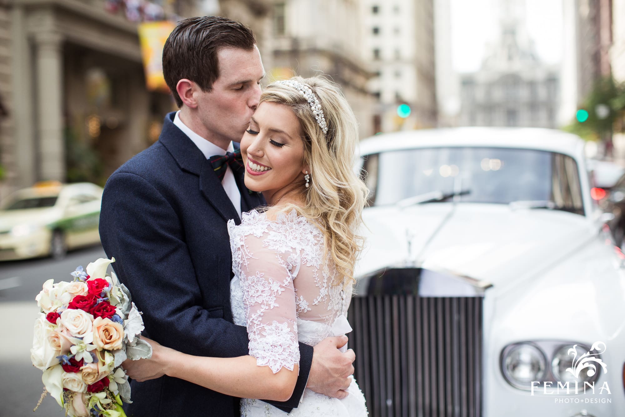 Lyall kisses his bride Rebecca on the forehead in front of their Rolls Royce on Broad St in Philadelphia
