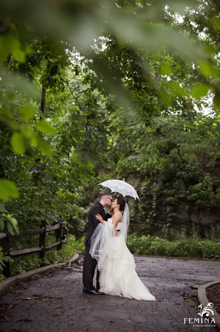 Marijela and Steven kiss under their umbrella among the trees