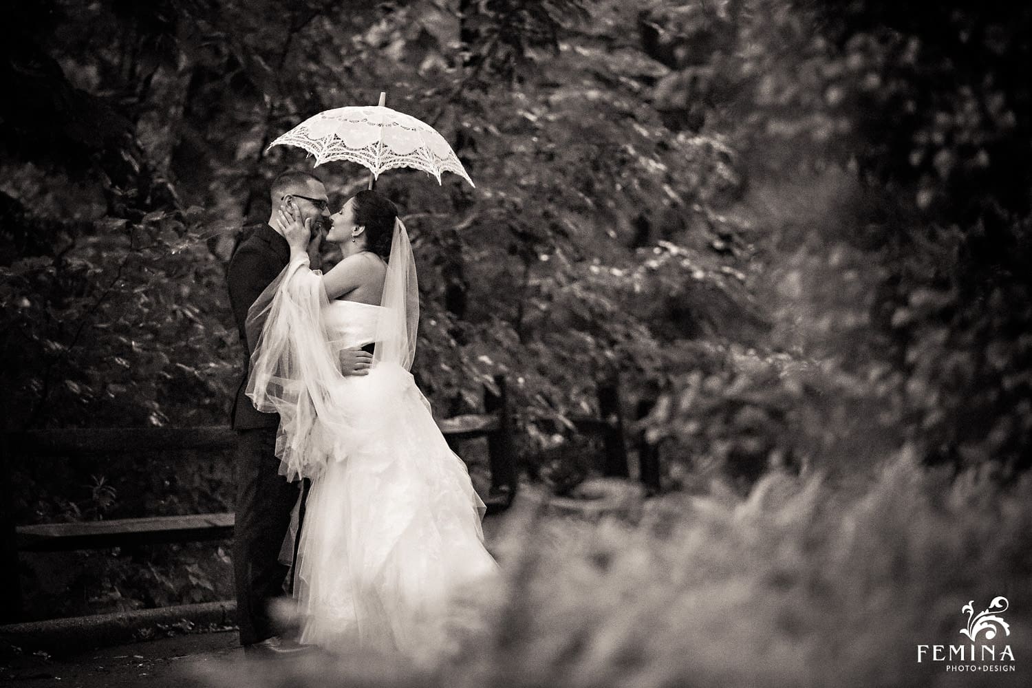 Marijela and Steven hold each other and smile under their umbrella