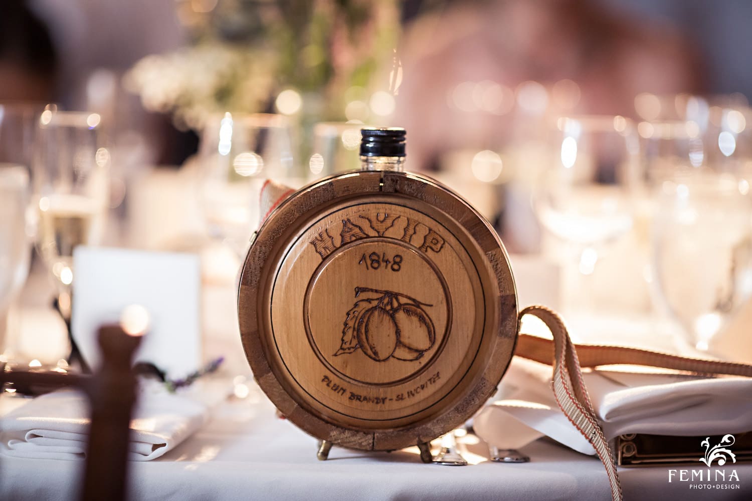 A wooden flask sits on the table at Marijela and Steven's wedding reception