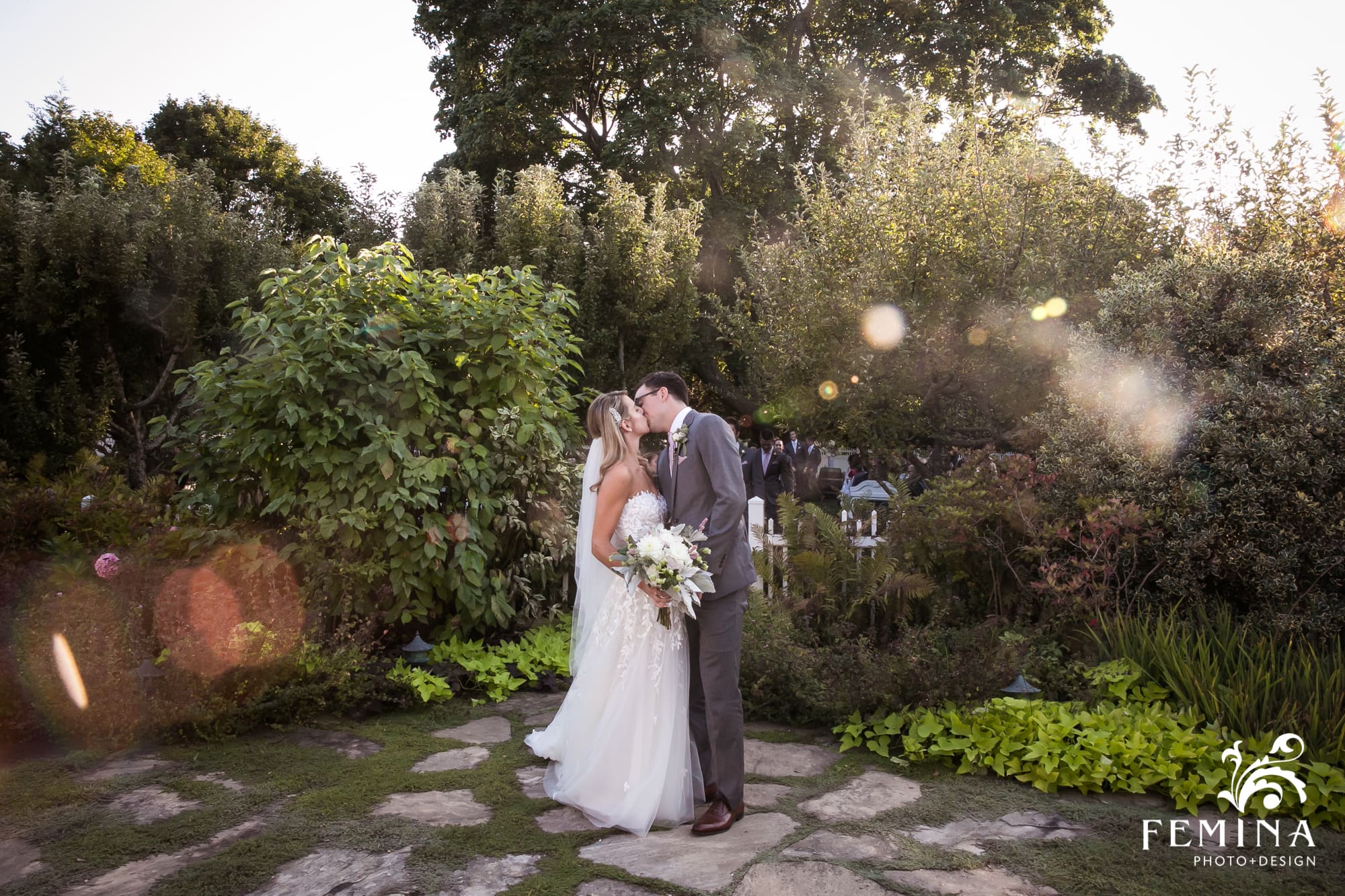 Lindsey and Tommy stop for a kiss in the garden of Bedell Cellars after their ceremony