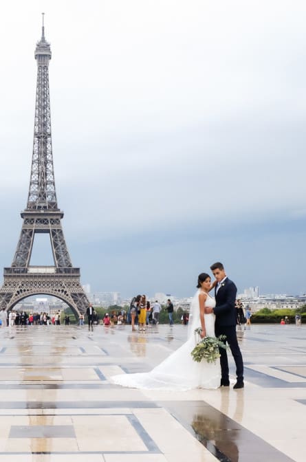 Shana and Hugo pose for wedding portraits in front of the Eiffel Tower