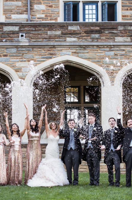 Michelle and Max throw confetti with their bridal party at Saint Andrews School in Delaware