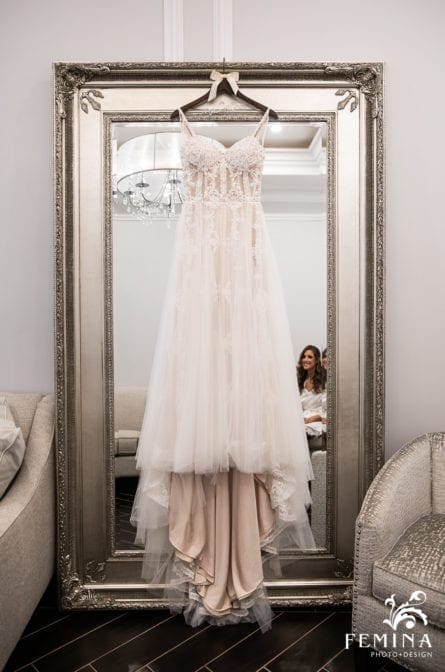 Bride's wedding dress hanging on a mirror