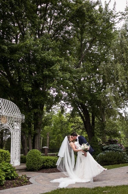 Groom dipping his bride in front of a gazebo at The Rockleigh