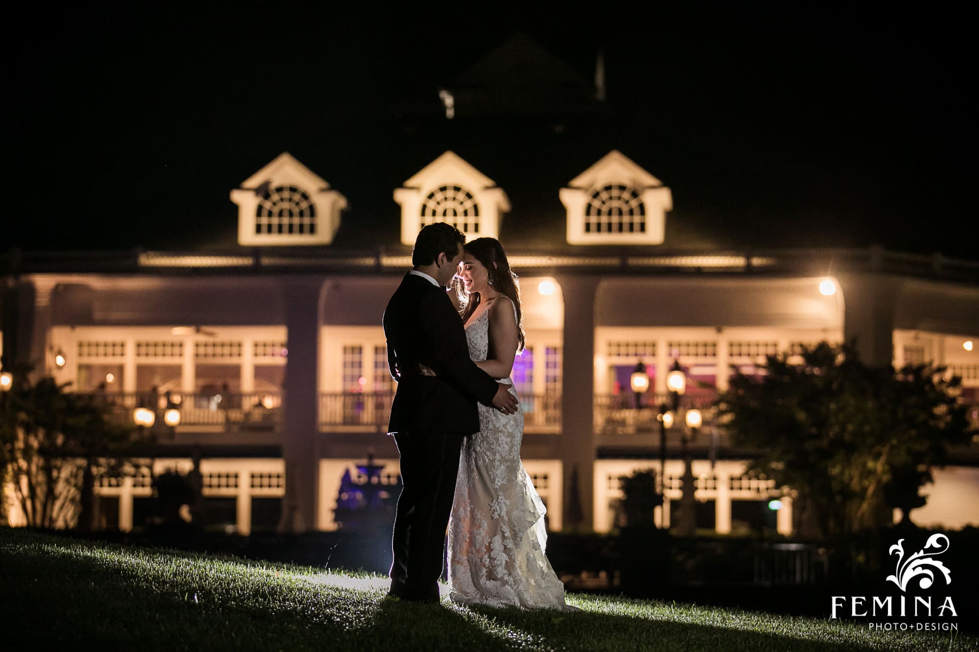 Bride and groom posing for a night shot in front of the wedding venue at Eagle Oaks Country Club