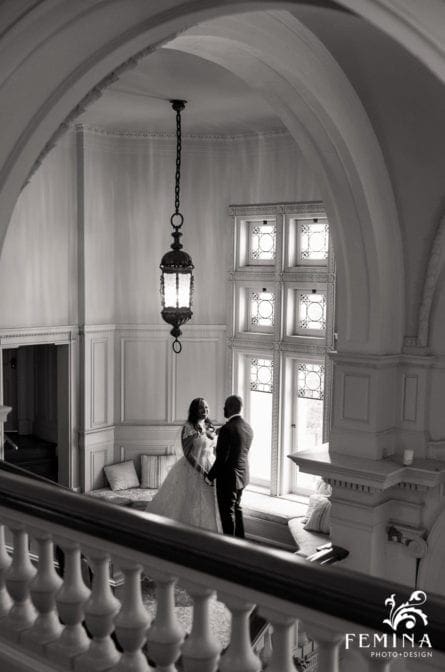 Bride and groom posing on the grand staircase at Cairnwood Estate