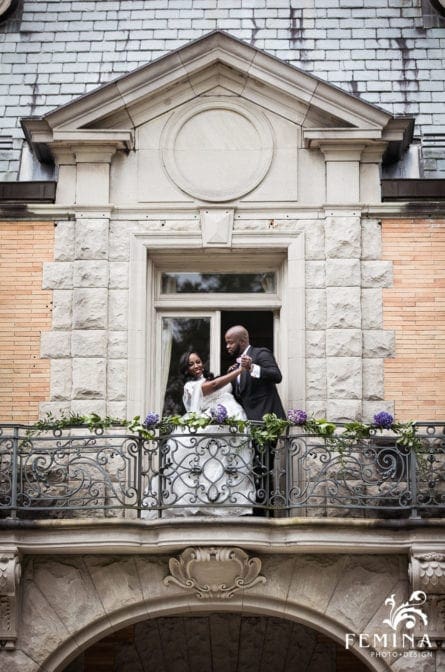Bride and groom on the balcony posing at Cairnwood Estate in Bryn Athyn PA