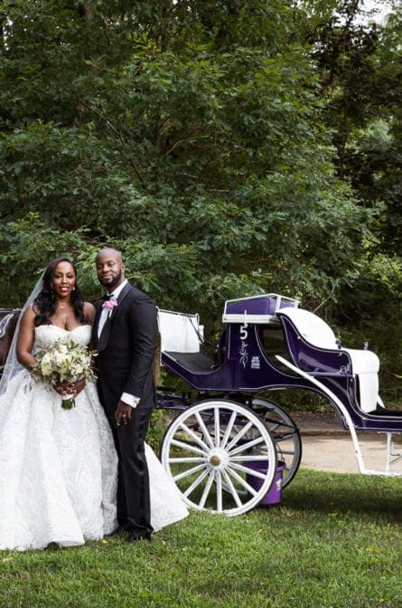 Bride and groom posing in front of a carriage at the Abington Arts Center