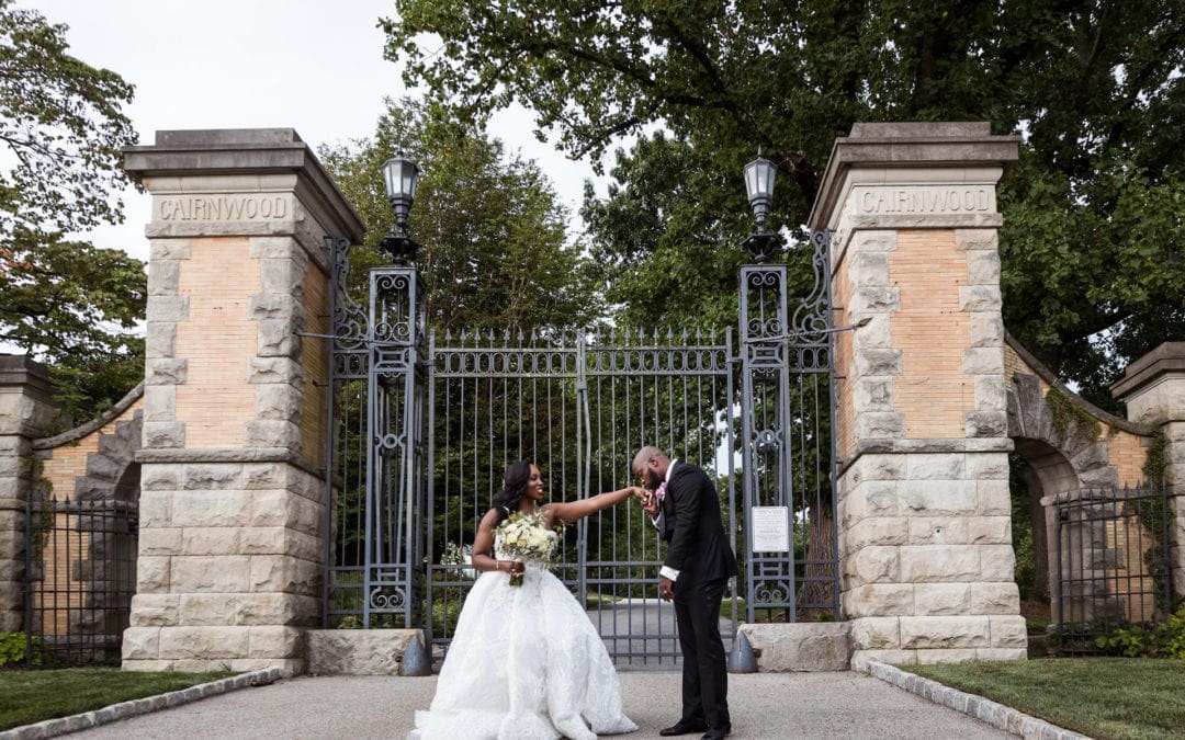 Couple posing in front of the gates at Cairnwood Estate