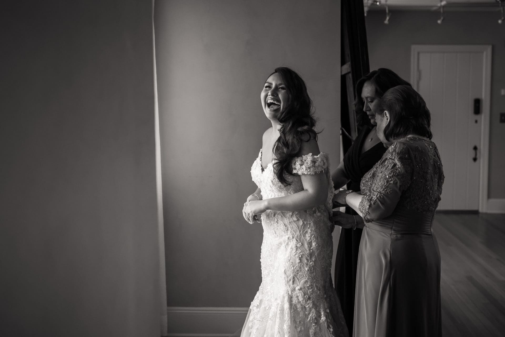 Bride getting into her wedding dress in the bridal suite at the Pleasantdale Chateau in West Orange, NJ