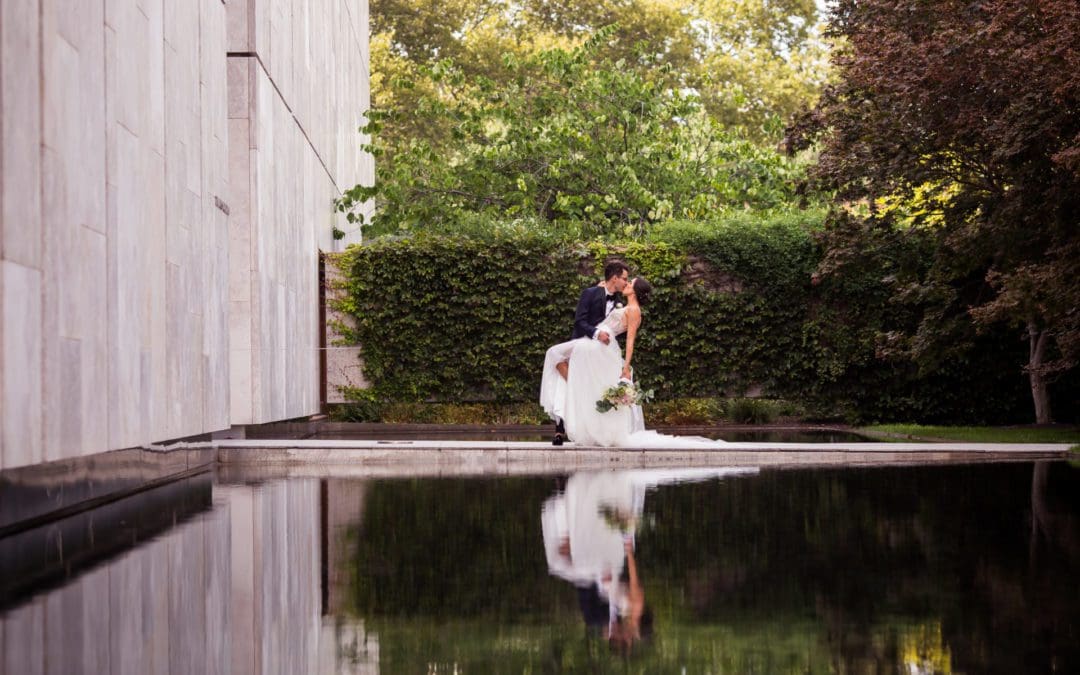 Groom kissing the bride in front of the reflection pool at the Barnes Foundation in Philadelphia