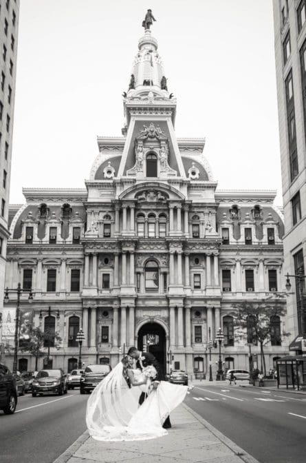 Bride and groom posing on broad street in Philadelphia