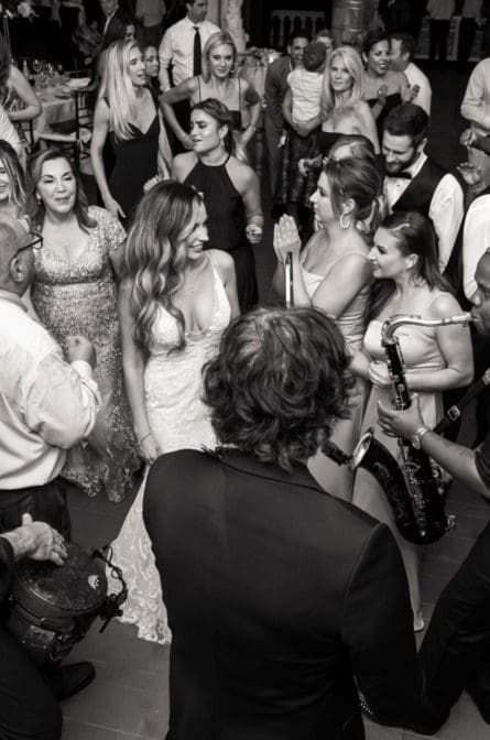 Black and white photo of the bride dancing with her bridesmaids during her wedding reception