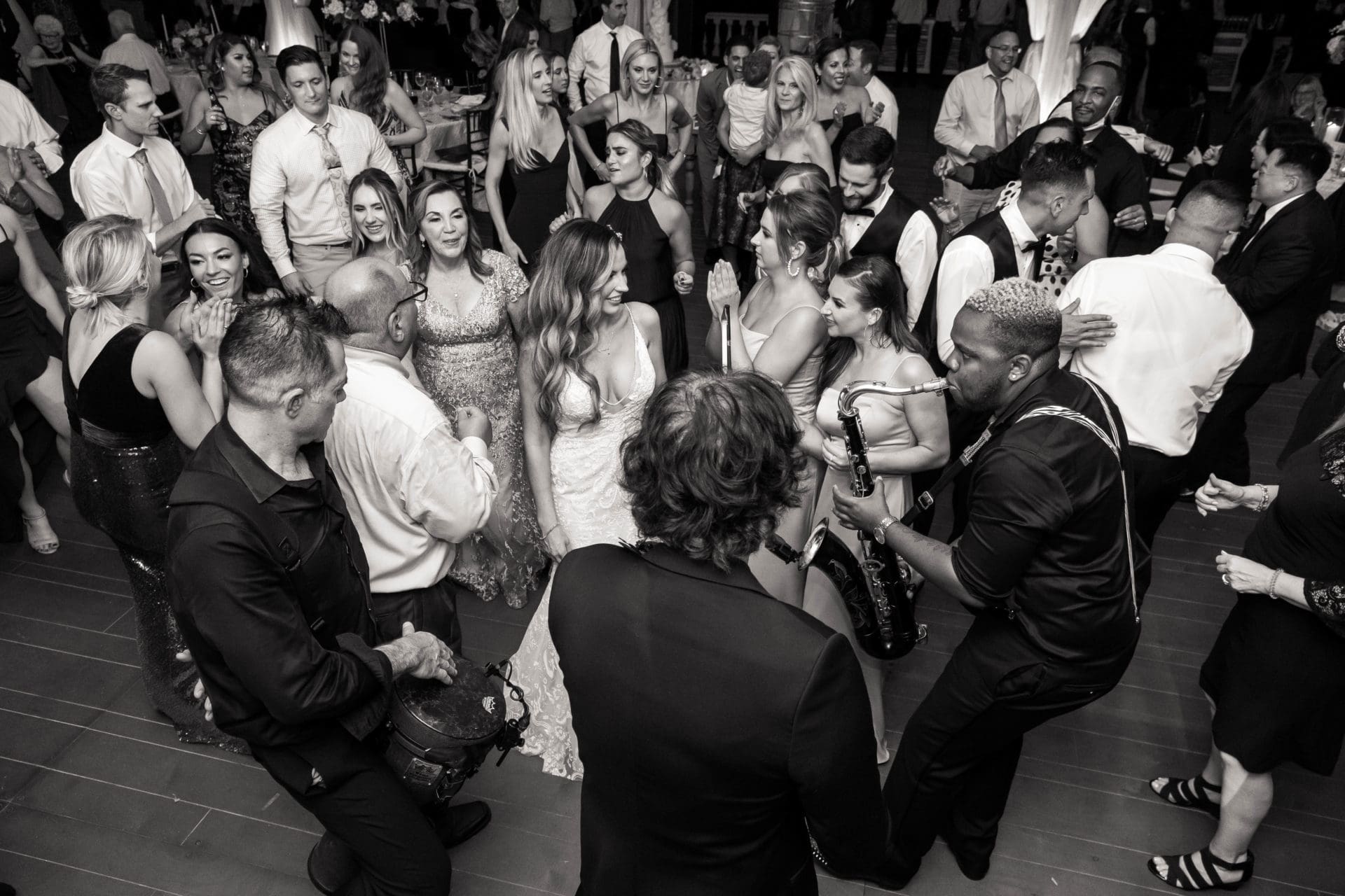 Black and white photo of the bride dancing with her bridesmaids during her wedding reception