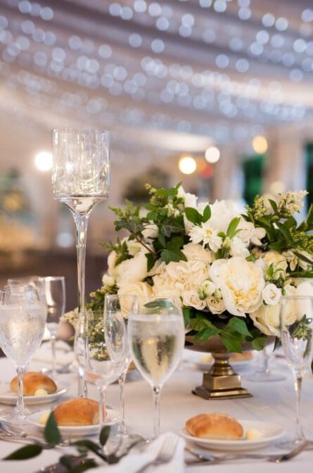 Close up of table decor with tall glass vases and candles in a large reception room at Lyndhurst Castle