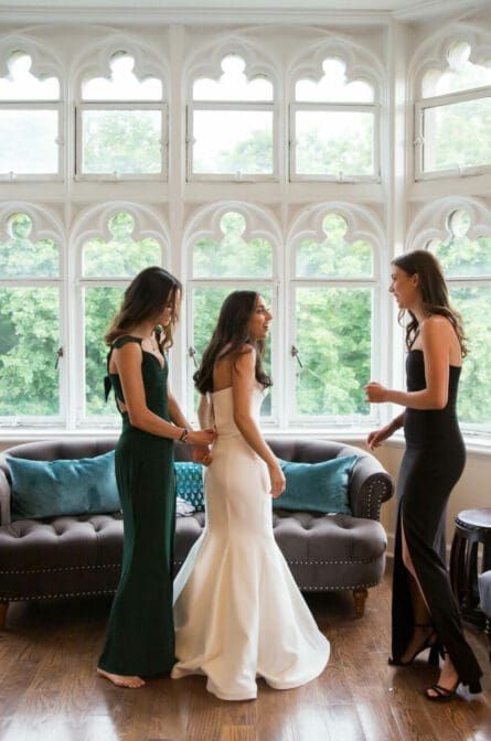 A bride gets dressed with her bridesmaids in the bridal suite at Hempstead House
