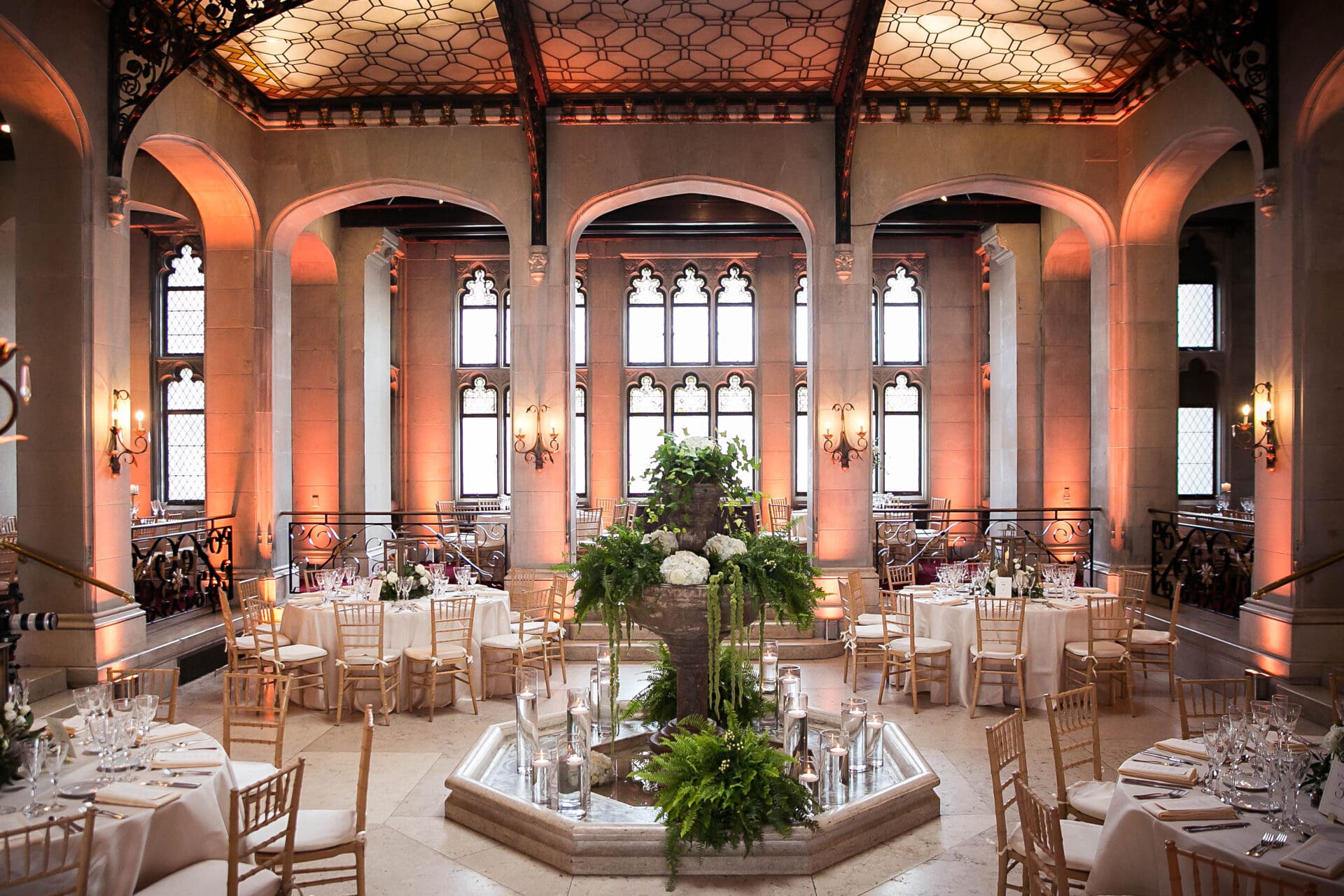 Wedding decor and cascading florals cover a fountain in the middle of the ballroom at Hempstead House in Sands Point NY