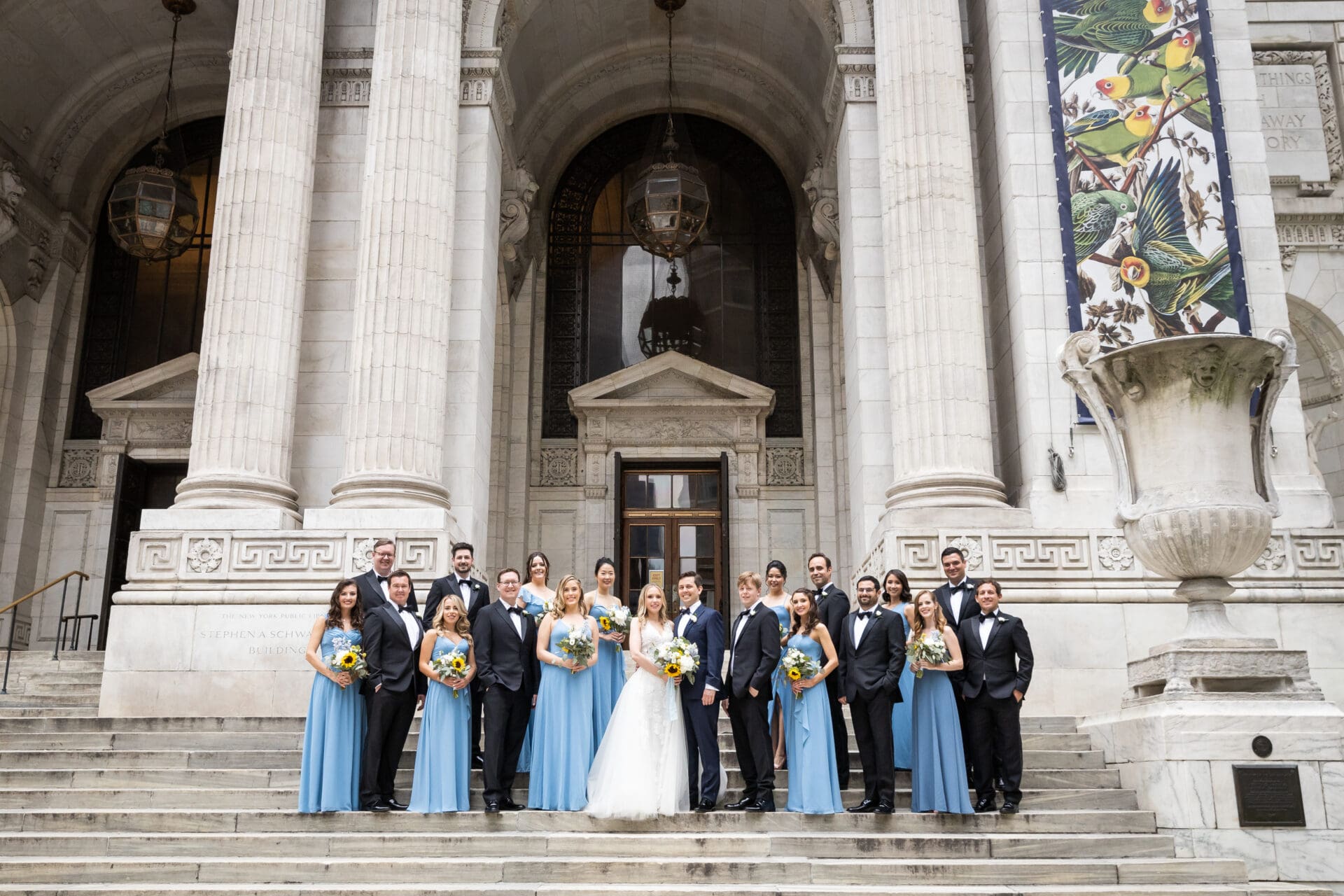 A wedding party poses on the steps of the New York Public Library during a photo session
