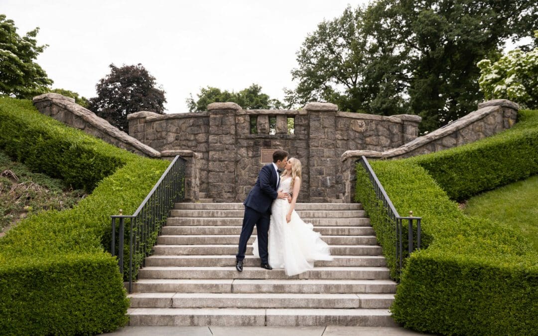 Bride and groom kissing on the steps in the Rose Garden at their NYBG Stone Mill wedding