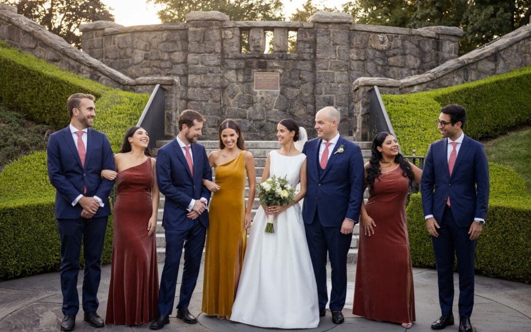 A wedding party poses in front of the stairs in the Rose Garden at the New York Botanical Gardens in the Bronx NY